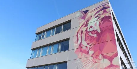 Außenwand des TIGER-Hauptquartiers in Österreich mit einem Tiger auf der auf die rechte Seite der Fassade gedruckt wurde